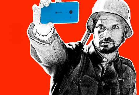Sotilaspukuun ja kypärään pukeutunut mies pitää sinistä älypuhelinta ylhäällä ikään kuin ottaisi selfietä. Kuva on tyylitelty mustavalkoiseksi, lukuun ottamatta puhelinta ja yhtenäistä kirkkaanpunaista taustaa.