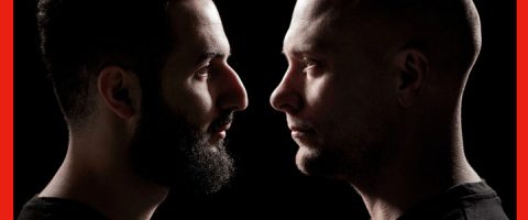 Kaksi miestä on vastakkain profiilissa mustaa taustaa vasten. Toisella miehellä on täysi parta ja tummat hiukset, kun taas toinen mies on partainen ja kalju. Molemmilla on vakavat ilmeet.