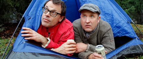 Pari miestä istuu teltassa.