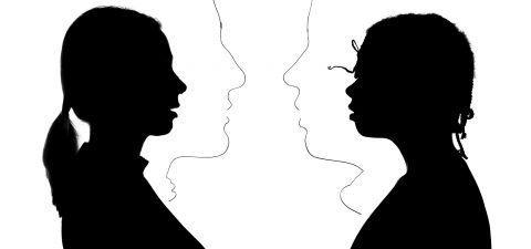 Kaksi ihmistä profiilissa, vastakkain mustassa siluettikuvassa; heidän välissään olevaan valkoiseen tilaan on hahmoteltu lisää profiileja, mikä luo optisen illuusion useista kasvoista kuvassa.