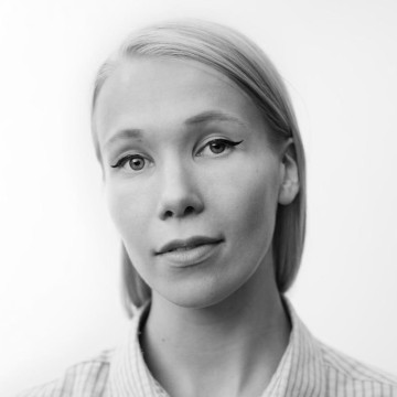 Mustavalkoinen muotokuva henkilöstä, jolla on suorat, vaaleat hiukset sivujakauksella kammattuna, päällään raidallinen kauluspaita. Henkilöllä on neutraali ilme, hän on kameraan päin tavallista taustaa vasten.